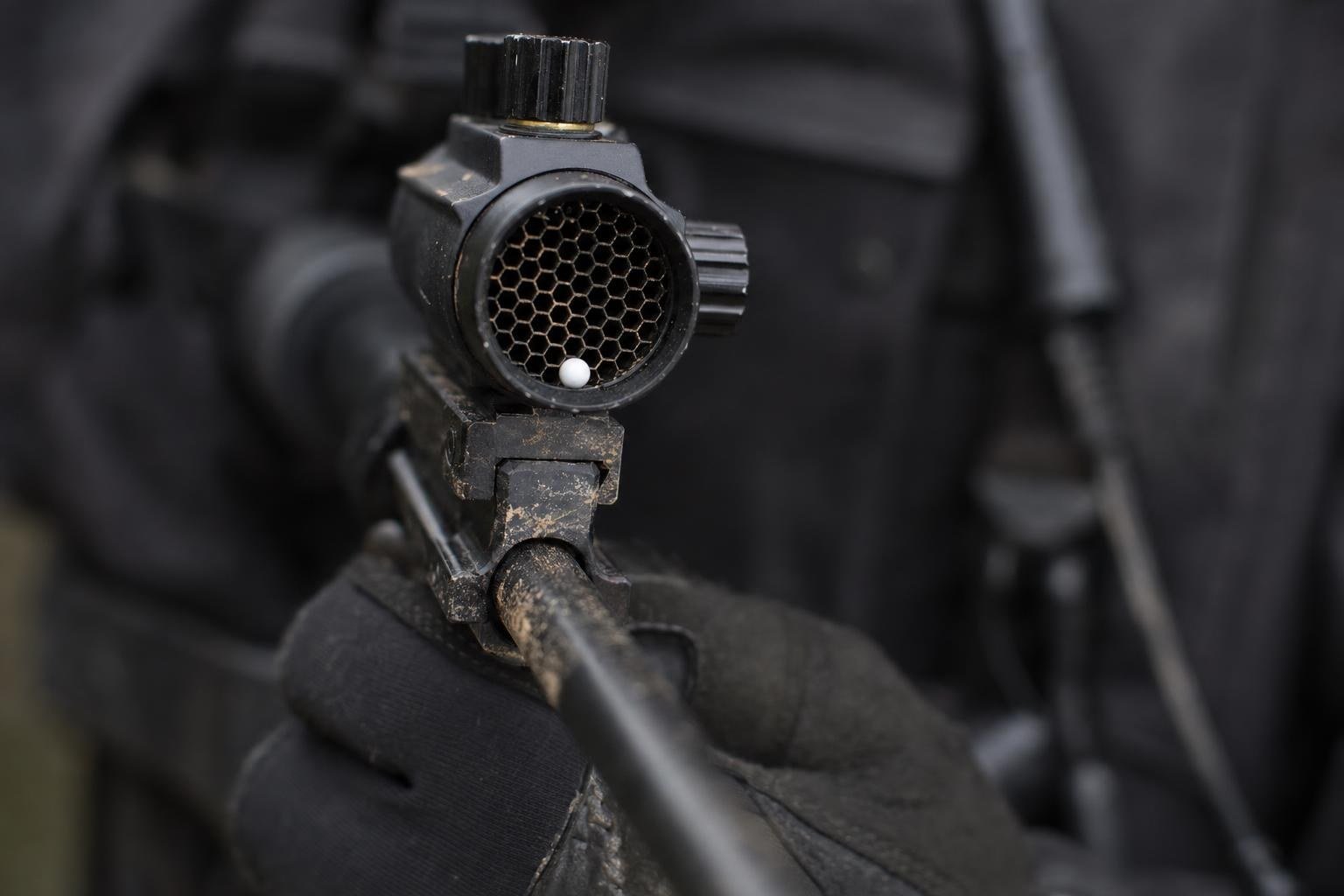 Close-up of a mesh lens protector fitted over the front of a sight