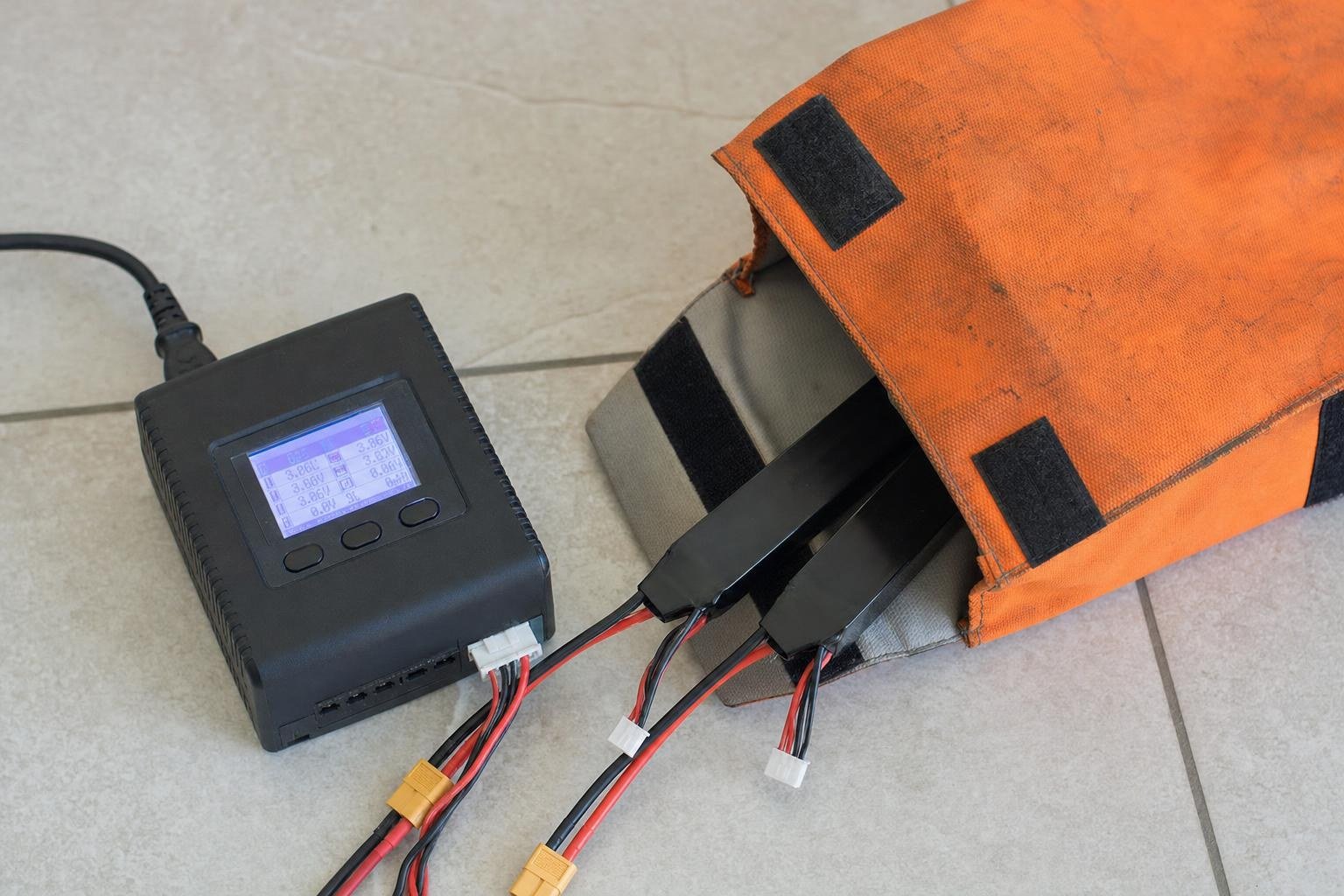 LiPo batteries stored in a fireproof bag next to a smart balance charger